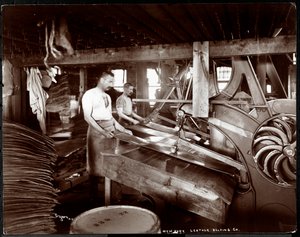 Innenansicht von zwei Männern, die mit Leder und schweren Geräten in der New York Leather Belting Co., New York, 1905 arbeiten